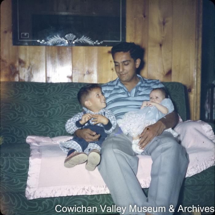 [Rajindi with two children on couch]