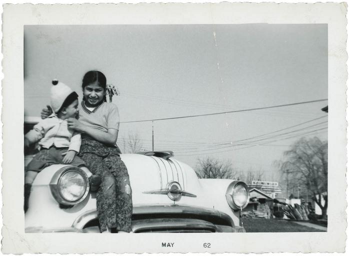 [Photo of two unidentified girls on a car bonnet]