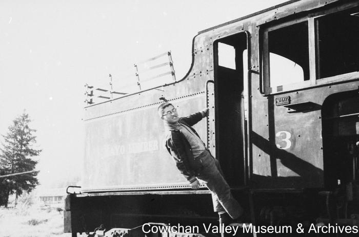 [Unidentified man holding onto railway locomotive]