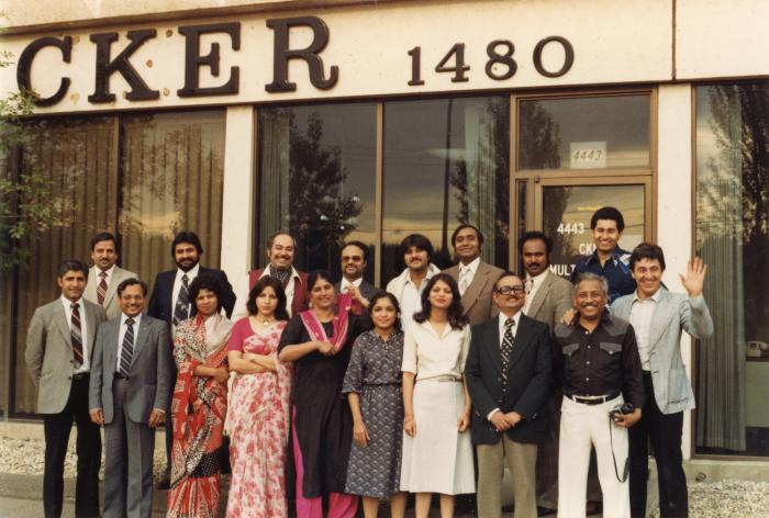[Photo of a group of people in front of CKER building]