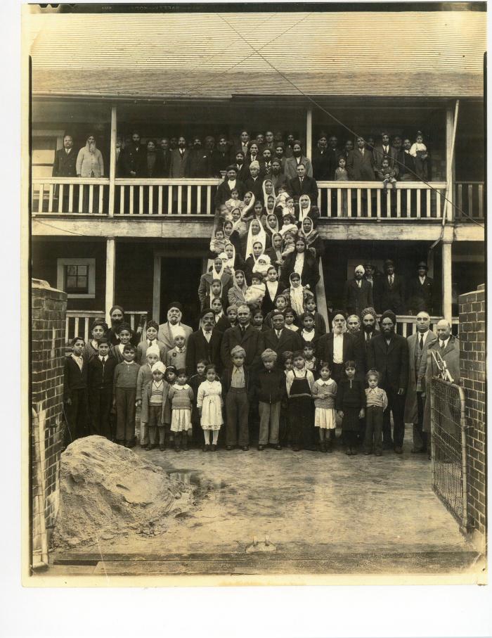 [Photo of Dr. Pandia and a group of community members in front of a gurdwara]