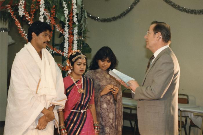 [Photo of a Tamil bride and groom with the officiant]