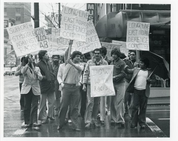 [Photo of a group of protestors holding anti-racist banners]