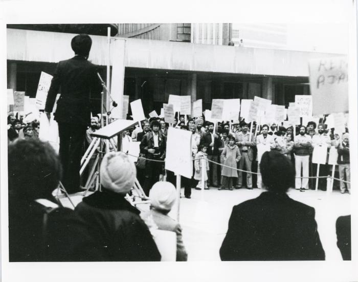 [Photo of an unidentified speaker at a protest]